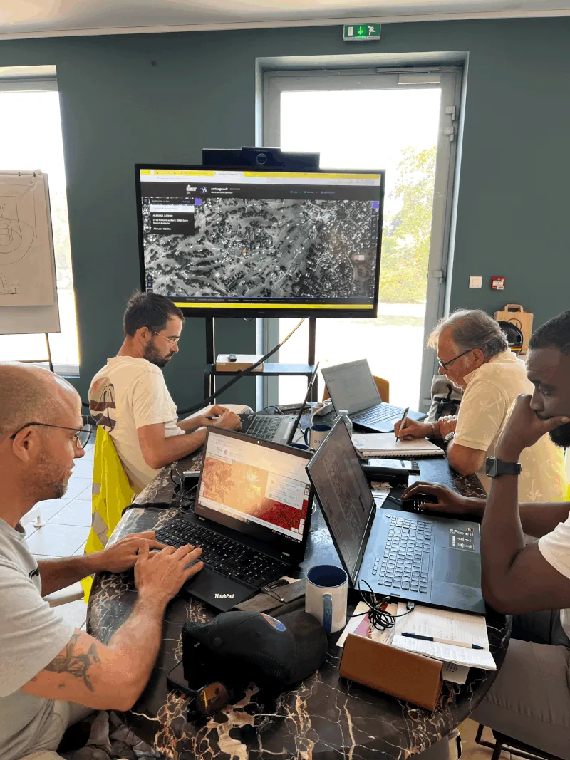 Trainees preparing a mission on laptops with an aeronautical map on screen — Dronexperts drone pilot training